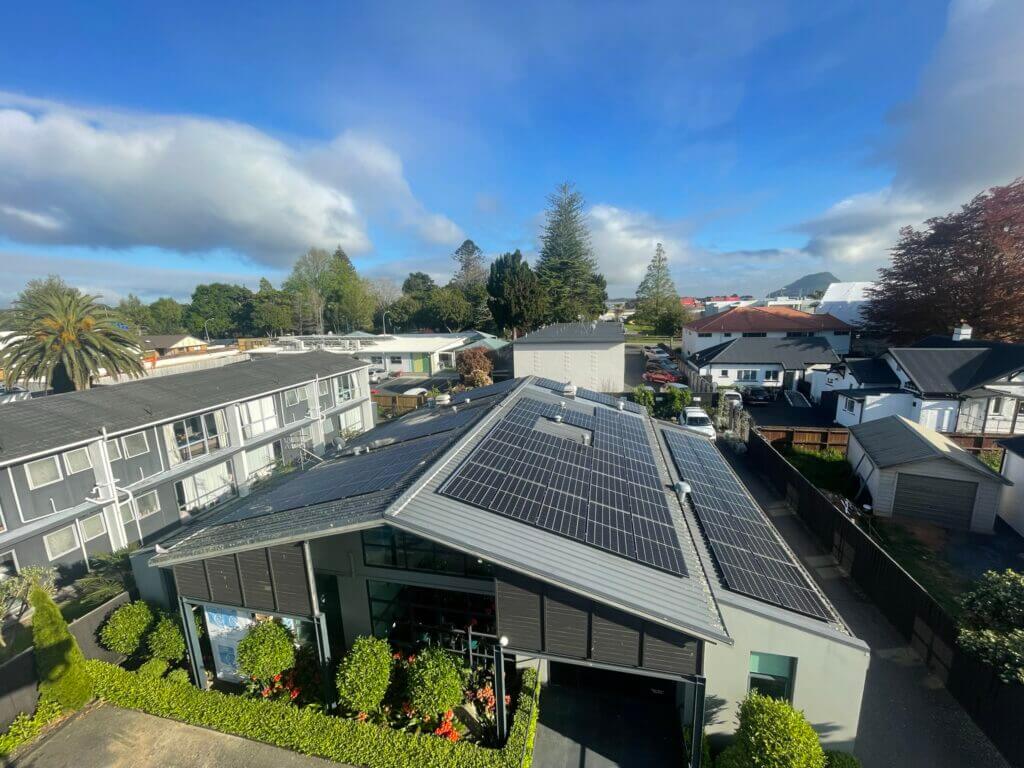 Aerial side view of a commercial healthcare building with solar panels.