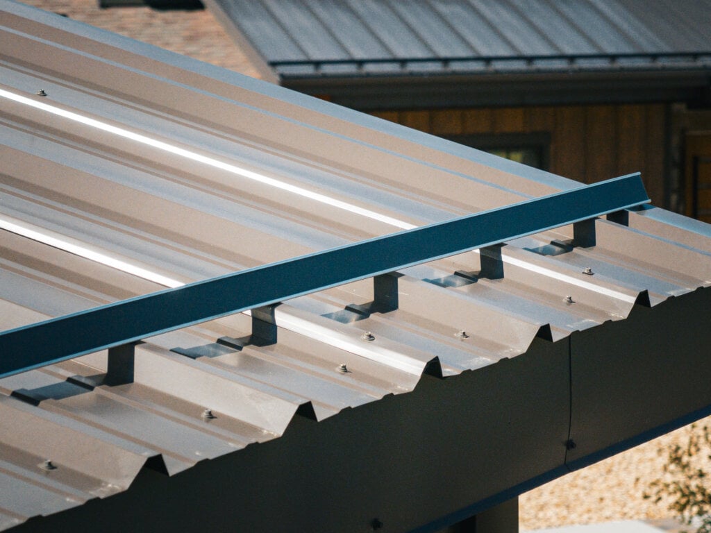 Grey corrugated metal roof with a thin blue metal strip running horizontally across the surface.